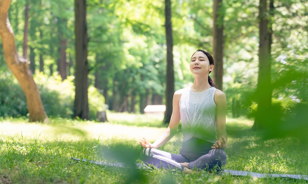 A woman starting yoga practice outdoors