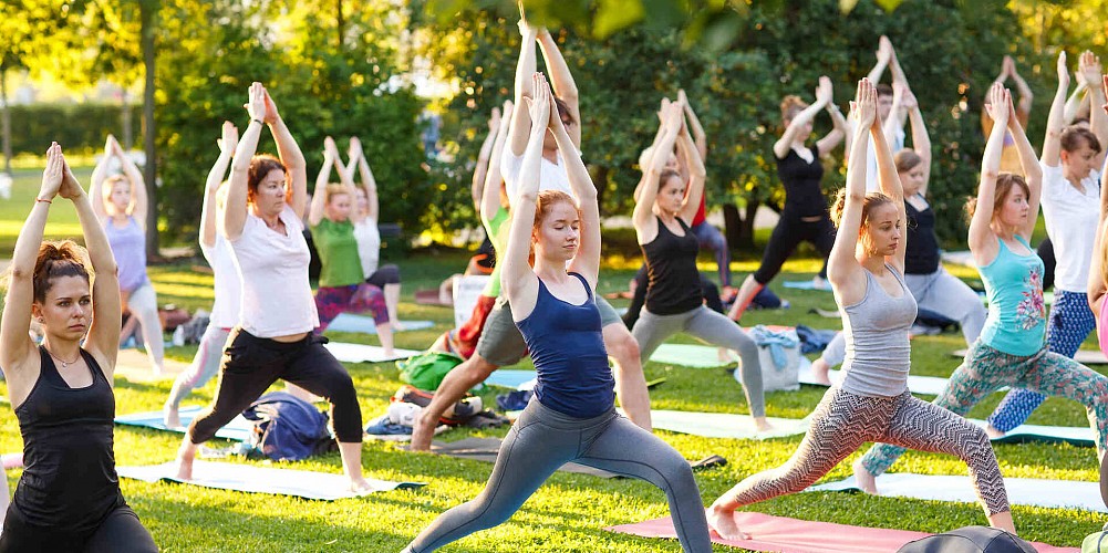 A large yoga class being taught outdoors